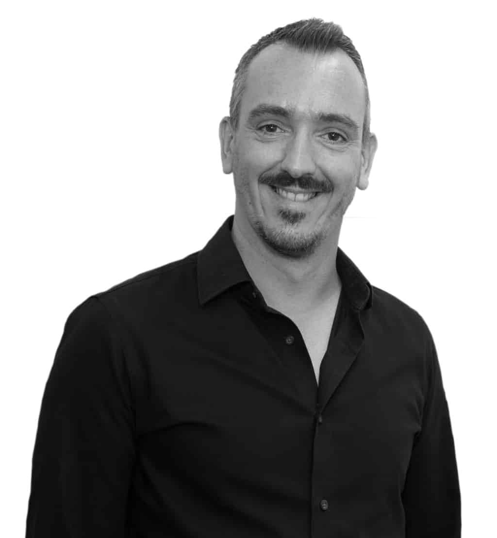 Professional headshot of Jerome wearing a dark button-up shirt, facing forward and smiling against a white background.