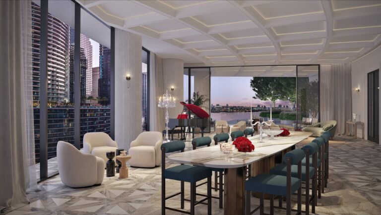 Social lounge at Baccarat Residences Brickell with marble floors, large dining table, lounge seating, and city and water views.