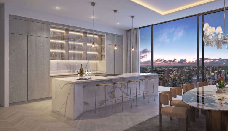 Modern kitchen at Baccarat Residences Miami with marble island, pendant lights, and city views at sunset.