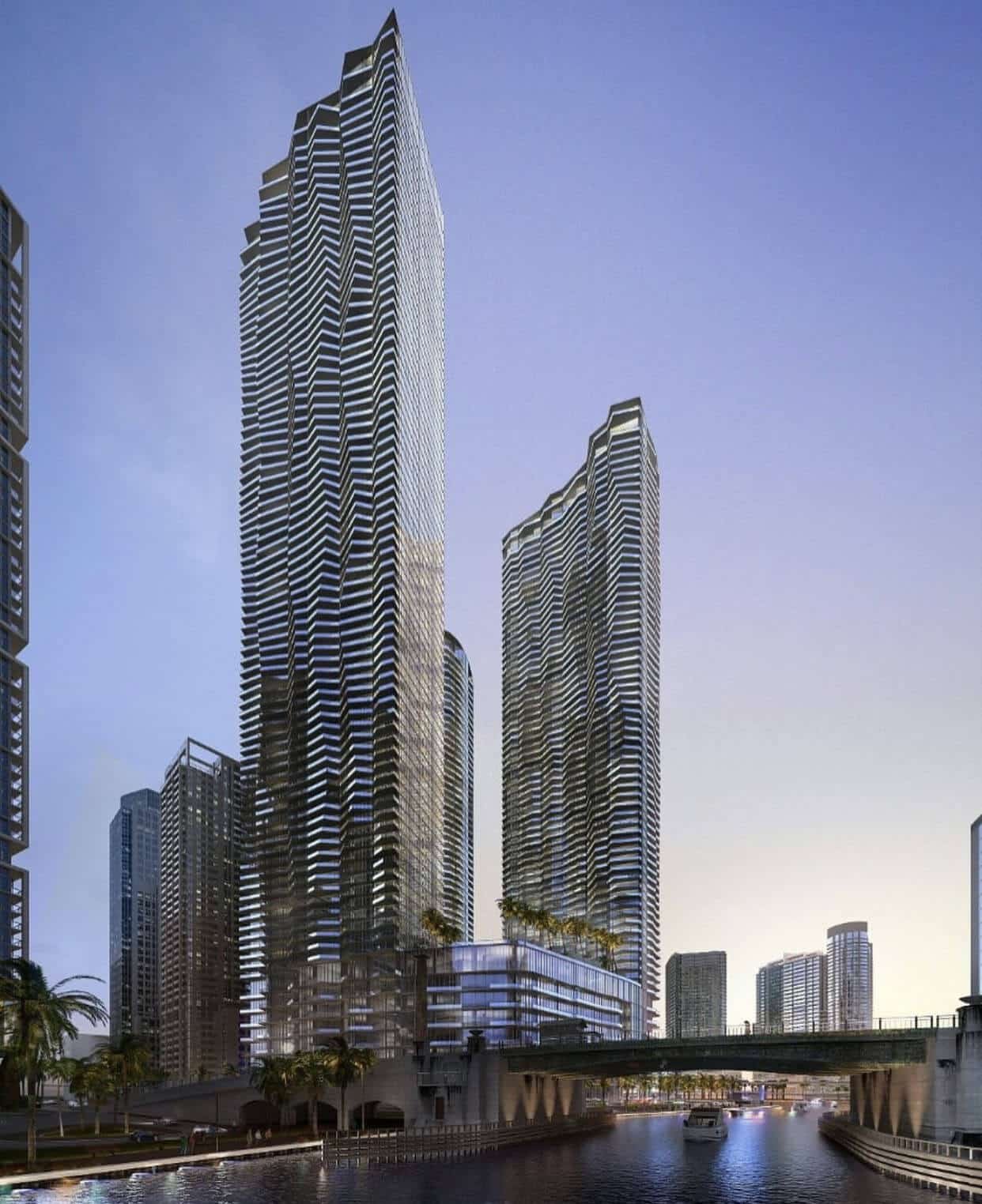 Waterfront view of Baccarat Residences Miami, featuring two glass towers rising above the Miami River in the Brickell district.