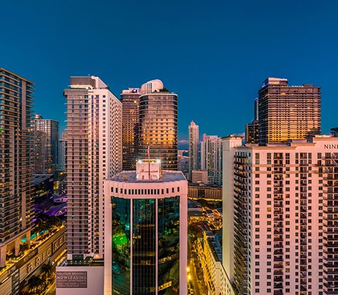 Evening cityscape showcasing a vibrant skyline illuminated against the twilight sky.