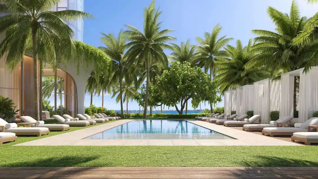 Outdoor pool deck with palm trees, lounge chairs, and shaded cabanas.