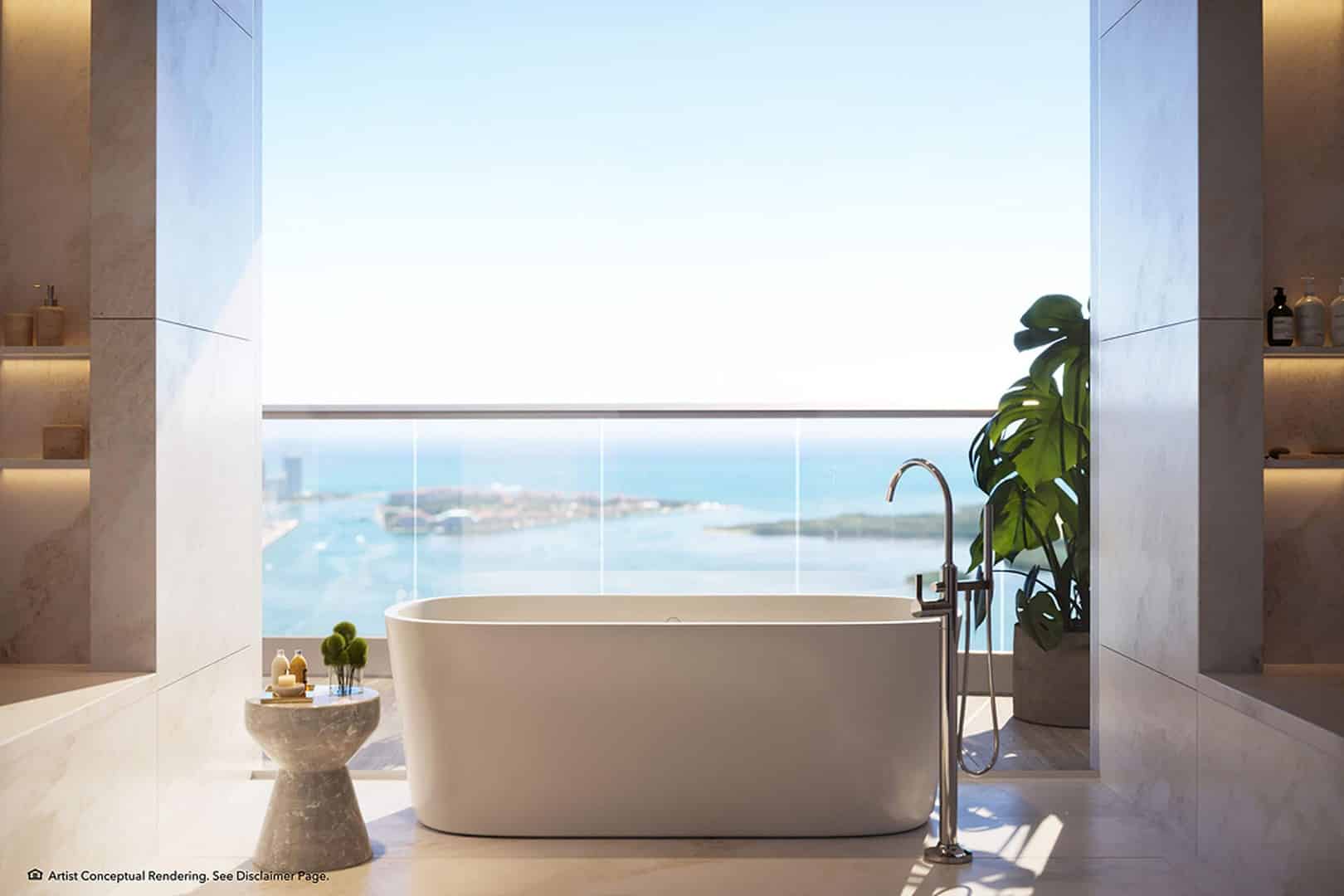 Luxurious bathroom with a freestanding tub facing a large window showcasing an ocean view. Marble walls, a plant, and candles create a serene atmosphere.