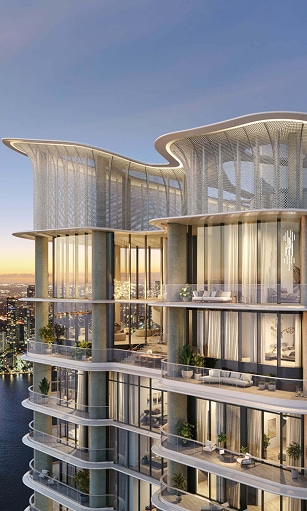 Futuristic high-rise against a sunset sky, overlooking a vast waterfront cityscape. The building features glass facades and curved, illuminated rooftops.