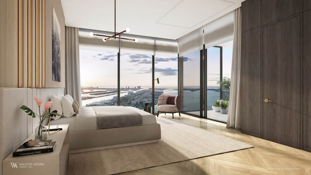 Luxurious bedroom with a large bed, modern decor, and floor-to-ceiling windows offering an ocean view at sunset. Austerity and tranquility blend seamlessly.