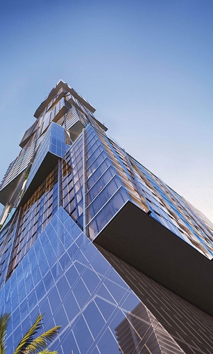 Skyscraper with angular glass façades reflecting the sky, viewed from below. Blue sky background with contemporary, geometric design and modern elegance.