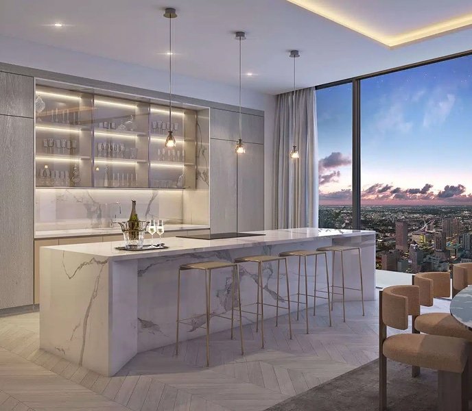 Modern kitchen at Baccarat Residences Miami with marble island, pendant lights, and city views at sunset.