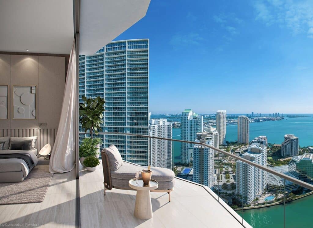 Balcony view with a stylish seating area, overlooking a modern cityscape and ocean under a clear blue sky. Adjacent bedroom with elegant decor.