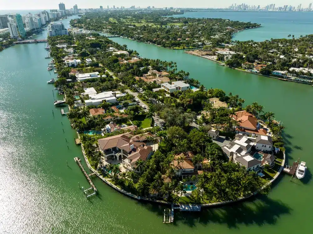 Aerial view of Allison Island with luxury waterfront homes, private docks, palm-lined streets, and calm bay waters in Miami Beach.
