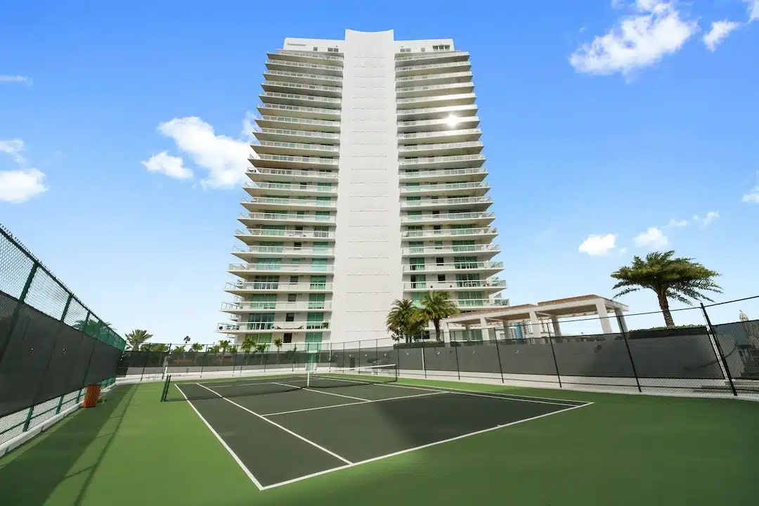 Tennis court and waterfront condominium building on Belle Isle, Miami Beach.
