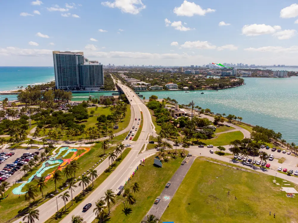 Aerial view of Haulover Park near Bal Harbour with coastal parkland, bridge access, turquoise waters, beachfront towers, and Biscayne Bay.