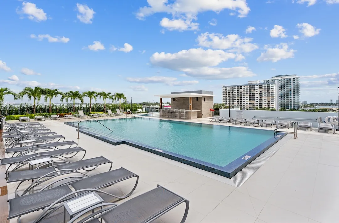 Rooftop pool deck with lounge chairs and bay views in North Bay Village Miami.