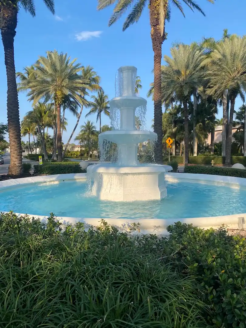 Decorative white fountain surrounded by palm trees at the entrance of Palm Island in Miami Beach.