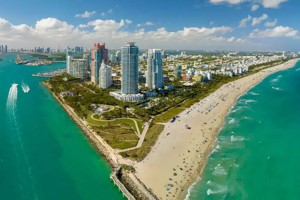 Aerial view of South Pointe Miami Beach with oceanfront shoreline, bay views, beachfront park, luxury condos, and turquoise waters.