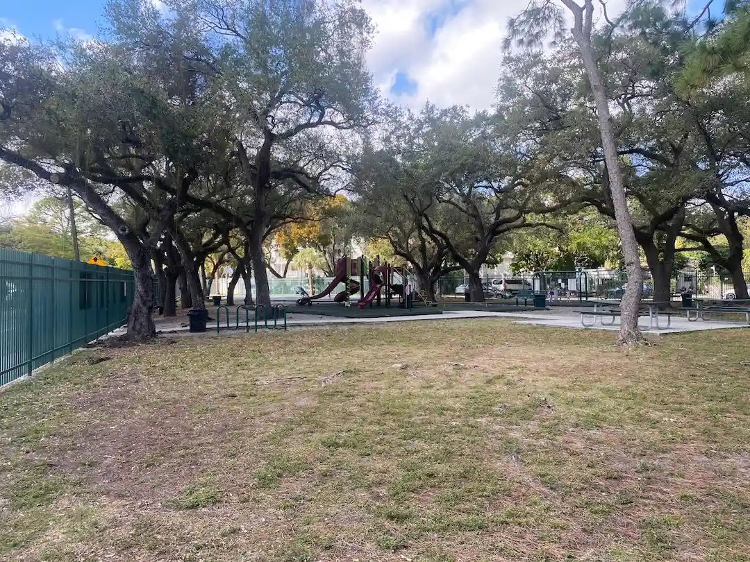 Neighborhood park with playground and mature oak trees in The Roads Miami residential area.